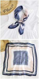 Detailed view of square silk scarf featuring geometric dot patterns and elegant blue borders