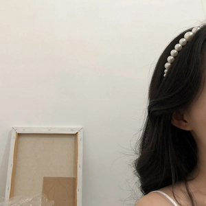 Elegant pearl headband for women featuring uniform milky white pearls on dark hair