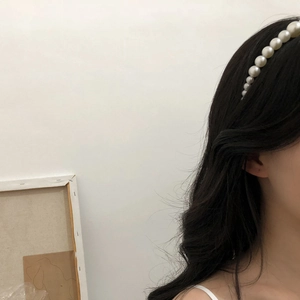 Detail view of a French vintage pearl headband worn by a woman with elegant hair styling