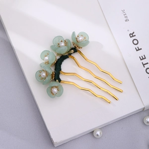 Detail of U-shaped gold hairpin with green frosted flowers and delicate white pearls