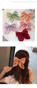 Detail of large silk fabric bow hair clip in various soft macaron colors for women