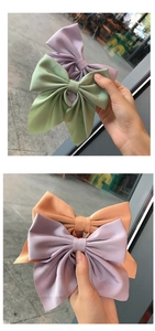 Detail of large satin bow hair clips in lavender, mint, and peach with silky texture