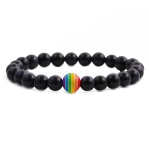 Blue goldstone bead bracelet with a central rainbow striped bead on white background