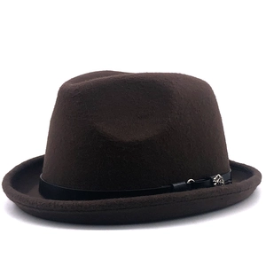 Detail of wool fedora hat featuring a brown felt texture and silver rose metal accent