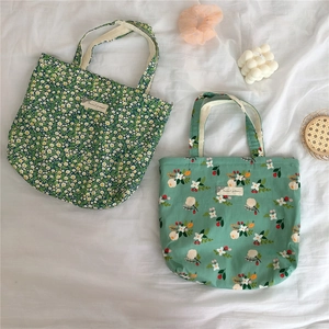Close-up of floral cotton tote bags with daisy prints and fabric labels in Ins style