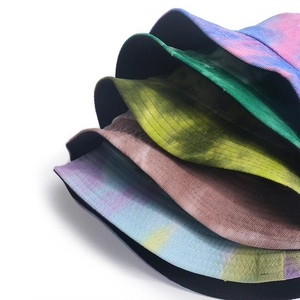 Close-up of stacked tie-dye corduroy bucket hats showing rich texture and vibrant colors