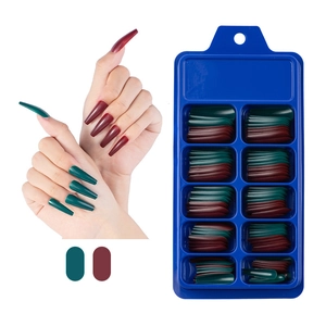 Detail view of matte dark green and burgundy coffin press-on nails with blue storage box