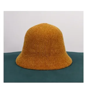 Detailed texture of thick ginger yellow chenille knit bucket hat with vertical ridges
