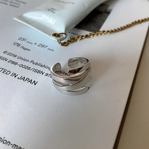 Detailed shot of S925 sterling silver woven ring on book with modern minimalist aesthetics