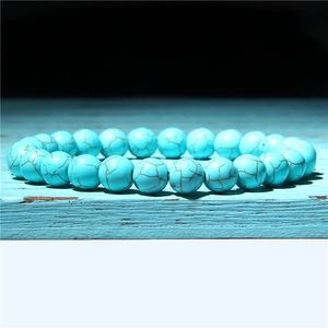 Detail of turquoise beaded bracelet with brown marble veins on vintage wood