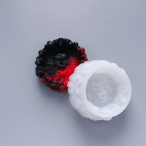 Macro detail of skull-themed silicone mold and finished resin ashtray with fire relief