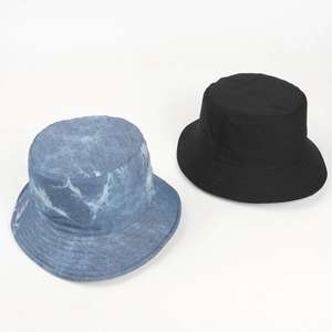 Detail of blue tie-dye and classic black cotton bucket hats with reinforced stitching