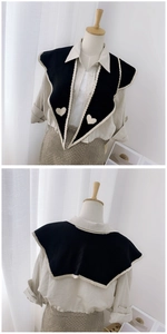 Detail of knitted black faux collar scarf with contrast beige piping and heart patterns