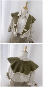 Close-up of olive green knitted collar featuring white heart patterns and piping details