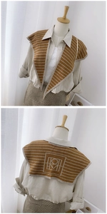 Detail of a brown and beige striped knitted shawl wrap showing the back geometric pattern