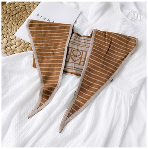 Detailed knit texture of a brown and beige striped shawl with geometric patterns