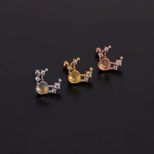 Détails macro de trois boucles d'oreilles croissant de lune en argent, or et or rose