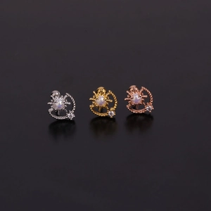 Détail de trois boucles d'oreilles soleil et lune en argent, or et or rose avec opale