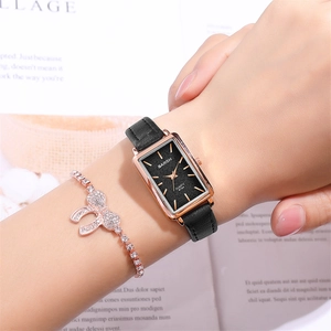 Detail of rose gold rectangular quartz watch and diamond bow bracelet on wrist
