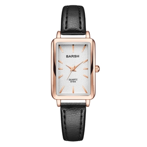 Close-up of rose gold rectangular quartz watch with white dial and black leather strap