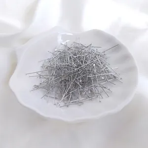 Flachkopstifte in Silber für Schmuckherstellung auf einer weißen Dekoschale