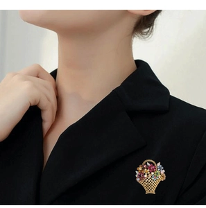 Close-up of a floral basket brooch with colorful crystals pinned on a black blazer lapel