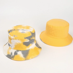 Detail shot of yellow cotton bucket hat and stylish tie-dye pattern sun cap for outdoors