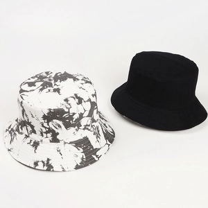 Detail of reversible tie-dye marble pattern and solid black cotton sun bucket hats