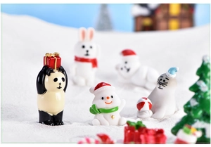 Close-up of resin winter figurines featuring a panda, rabbit, snowman, and seal decorations