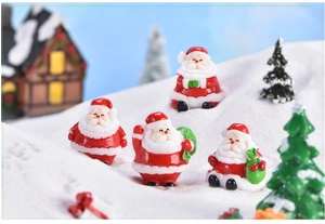 Detailed macro shot of miniature Santa Claus figurines in a snowy DIY Christmas micro landscape