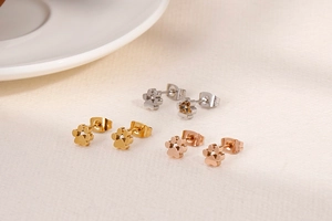 Détail de boucles d'oreilles patte de chat en acier or, argent et or rose