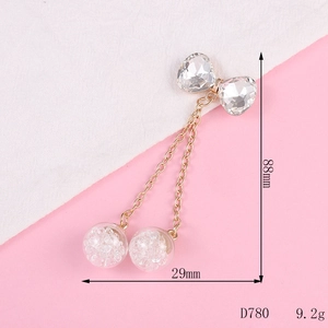 Detail showing bow pendant dimensions of 88mm length with glass spheres and gold chains
