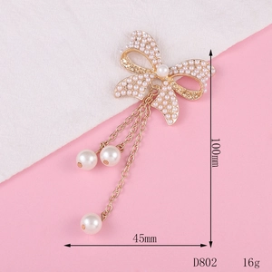 Golden bow brooch with white pearls and long chain tassels for jewelry making