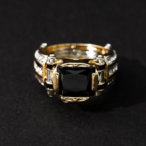 Macro view of men's ring with square black stone, gold-silver band and pavé white diamonds