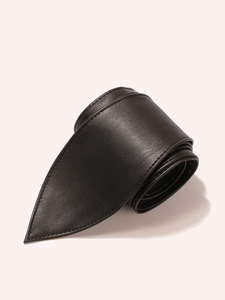 Detail of black leather waist belt showing lychee texture and fine stitching on pointed tip