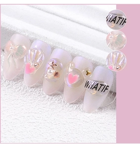 Detail van 3D-vlinders, parelschelpen en roségouden zeester-nagelkunstdecoraties