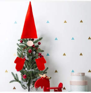 Detailed view of a red plush gnome-style Christmas tree topper set with hat and mittens