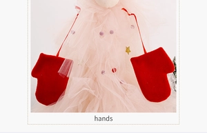 Detail of red festive mittens hanging on pink tulle with golden glitter stars
