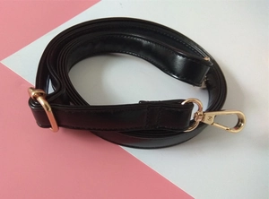 Detail of adjustable black PU leather shoulder strap with gold metal lobster clasps