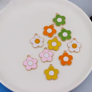 Detailed close-up of colorful enamel flower charms with gold edges for DIY jewelry