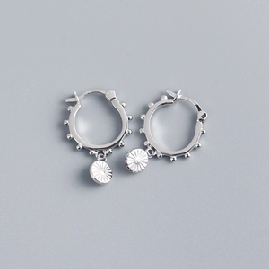 Detail of S925 sterling silver hoop earrings with sun pattern round pendants