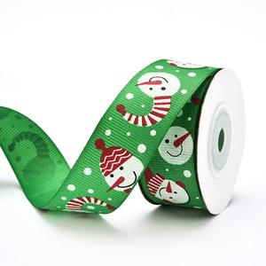 Detail of green ribbed Christmas ribbon with snowman patterns and white dots for gifting