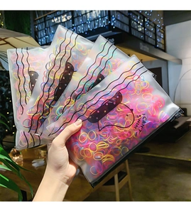 Detail of colorful disposable elastic hair bands in a printed transparent zipper bag