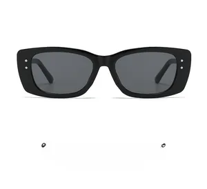 Detailed view of black square frame sunglasses with silver rivet accents and grey lenses