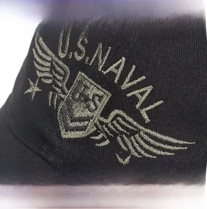 Detailed close-up of embroidered U.S. NAVAL logo on a black cotton baseball cap