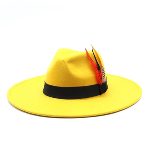 Detail of a bright yellow wide-brim wool fedora hat with black band and colorful feathers