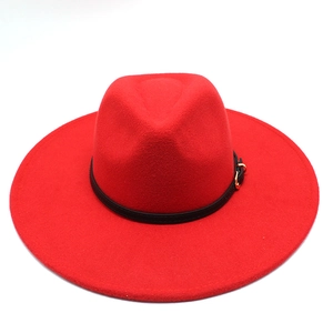 Close-up of red wool fedora hat crown featuring black leather band and gold buckle detail