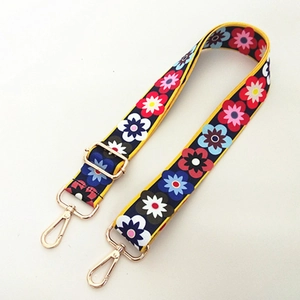 Detailed view of dark blue floral shoulder strap with gold metal buckles and adjuster