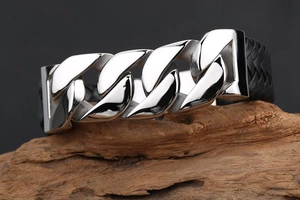 Detail of silver stainless steel Cuban links intertwined with black braided leather band