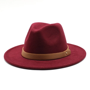Detail of burgundy fedora hat featuring a brown faux leather band and gold stud accent